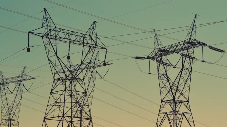 Augstsprieguma elektrības pārvades torņi pretī skaidrām debesīm Latvijas energoapgādes sistēmā.