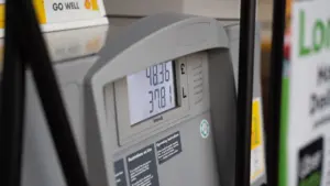 Tuvplānā redzams degvielas sūknis ar skaitītāju, kas rāda uzpildes datus un cenu.