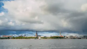 Rīgas panorāma ar tumšiem lietus mākoņiem virs Daugavas upes Latvijas galvaspilsētā.